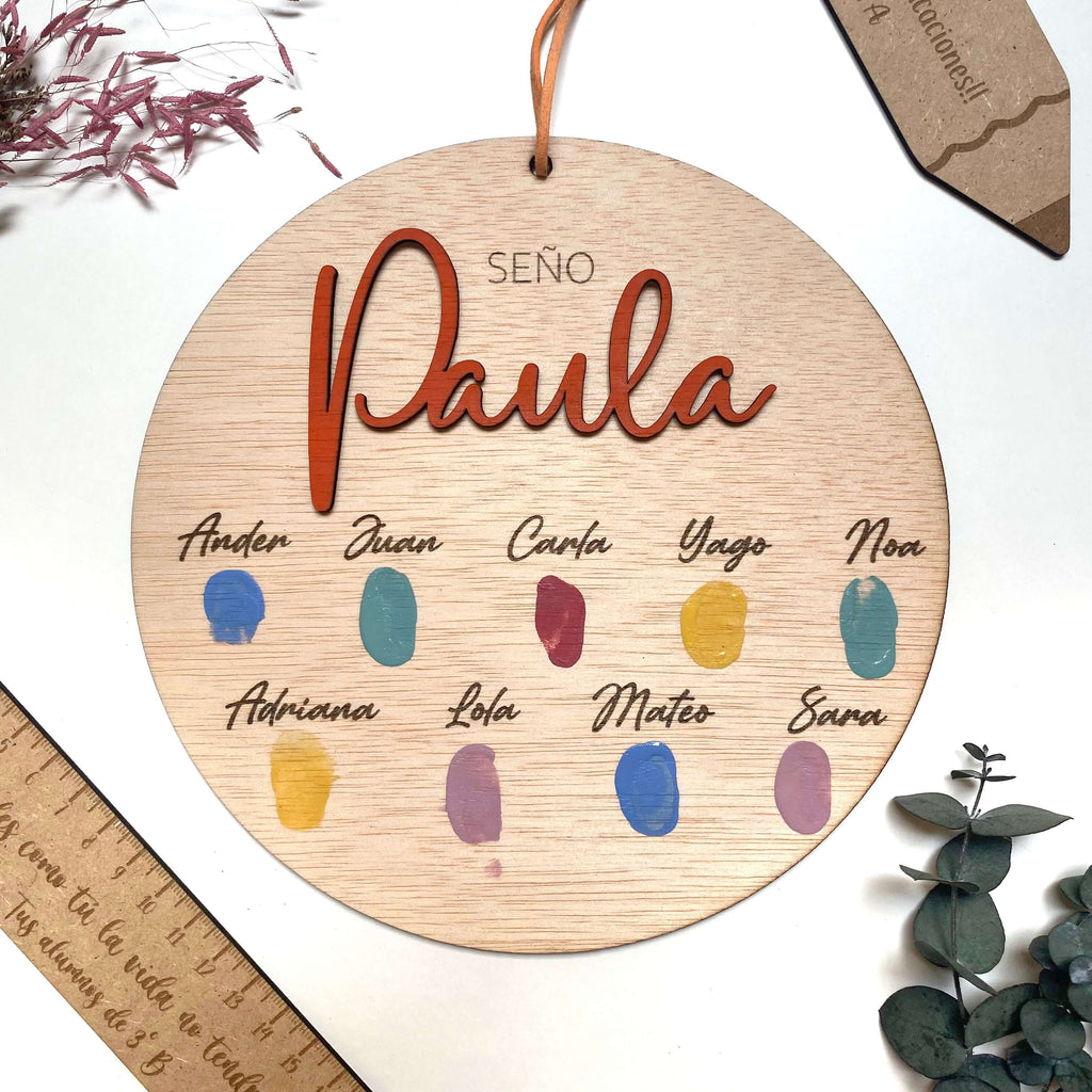 Circulo de madera grabado a láser en el que están estampadas huellas infantiles.